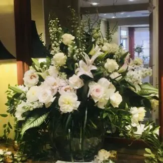 Half moon shaped vase filled with all white flowers